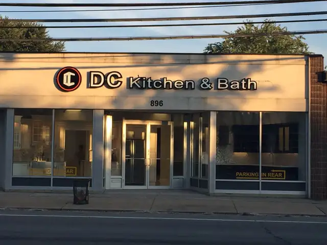 Front of the DC Kitchen & Bath showroom at 896 Old Country Rd, Westbury, lit up at dusk